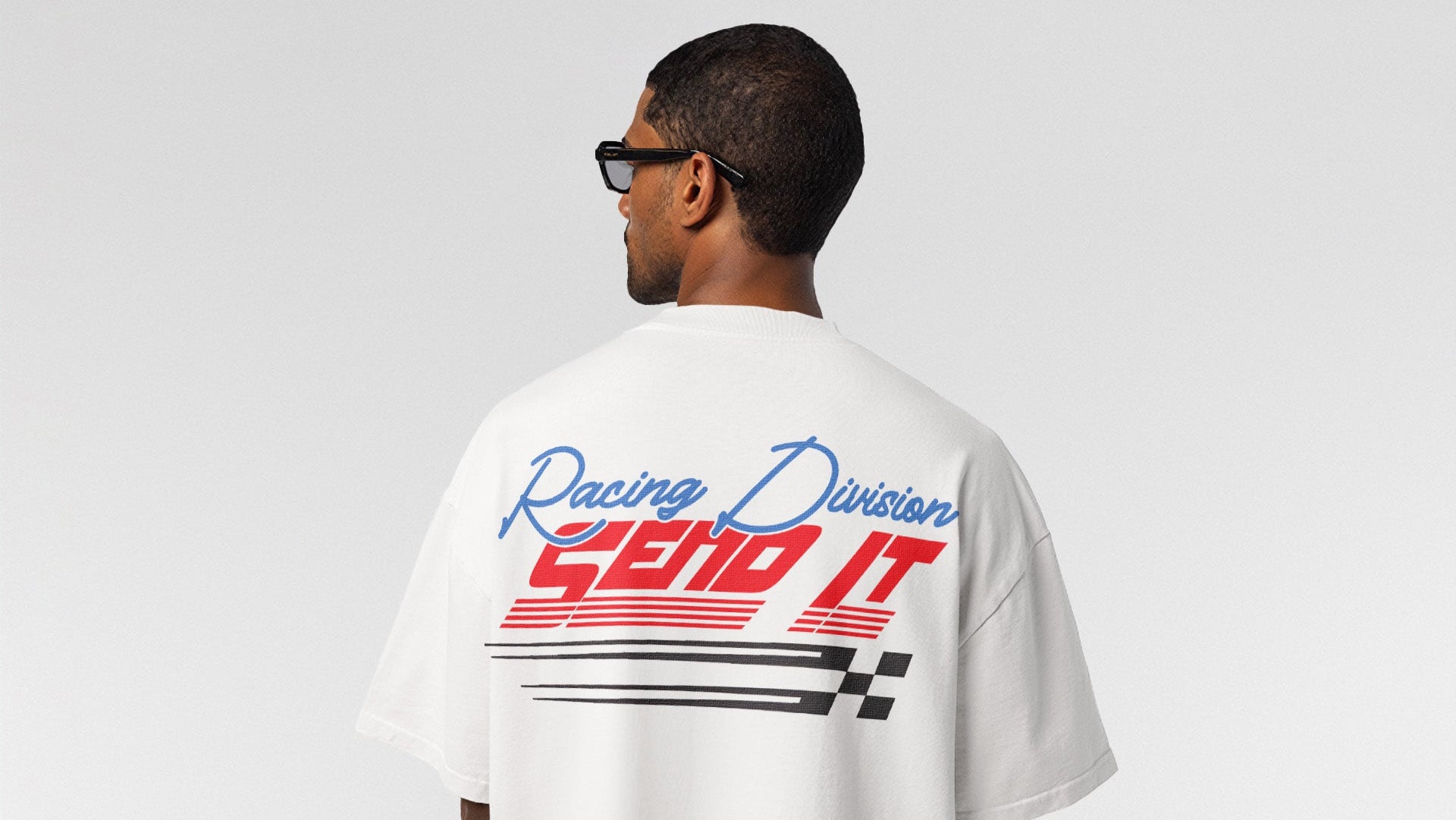 Person wearing a white t-shirt with 'Send It Racing Division' text and design on the back, standing against a plain background.