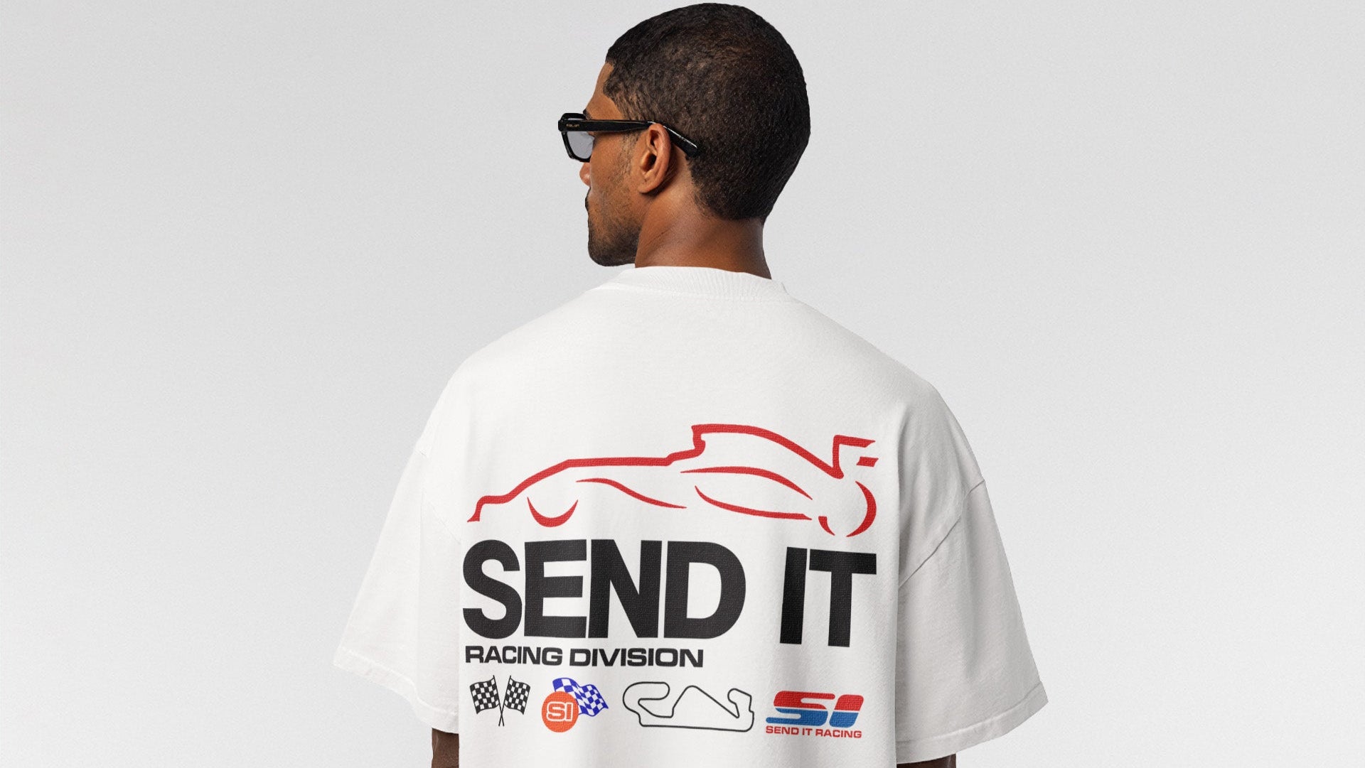 Person wearing a white t-shirt with 'SEND IT Racing Division' text and logos on the back.